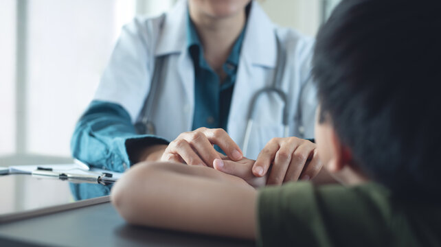 Female pediatrist doctor reassuring her young boy patient at medical clinic. healthcare and medicine concept.