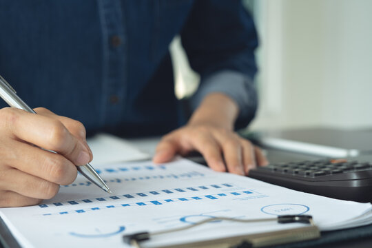 Business woman analyzing financial report with corporate document and calculator on office desk, close up