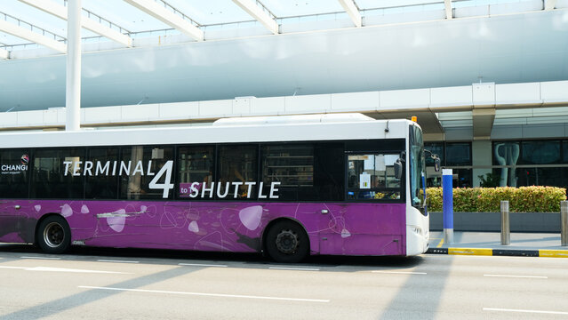 Singapore on 14 April 2026: Terminal 4, Changi Airport. this shuttle bus ferries passengers to and fro Terminal 1 and Terminal 4. it is parked outside the terminal's modern covered walkway
