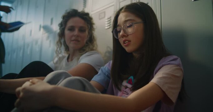 Dedicated Educator Finds Quiet Moment to Sit with Struggling Student near School Lockers, Offering Reassurance Through Empathy and Genuine Attention. Emotional Care, Teacher Mentorship, Resilience.