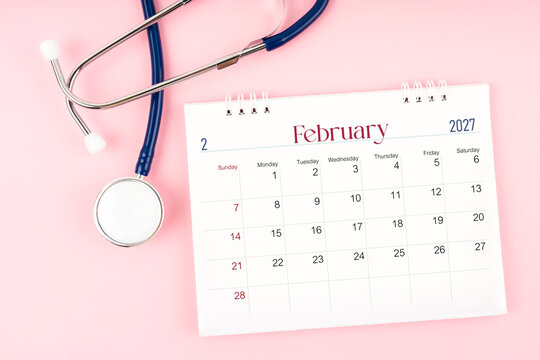 Blank February 2027 desk calendar and stethoscope, Medical appointment schedule to check up.