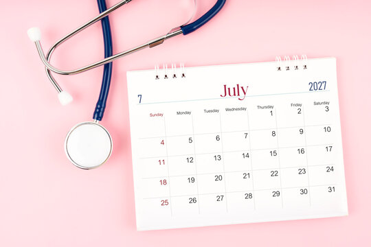 Blank July 2027 desk calendar and stethoscope, Medical appointment schedule to check up.