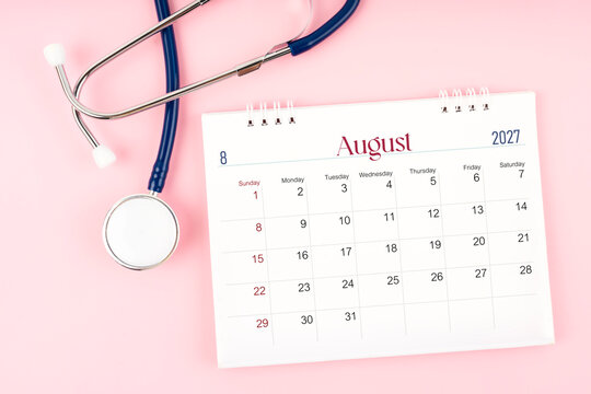 Blank August 2027 desk calendar and stethoscope, Medical appointment schedule to check up.