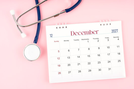 Blank December 2027 desk calendar and stethoscope, Medical appointment schedule to check up.