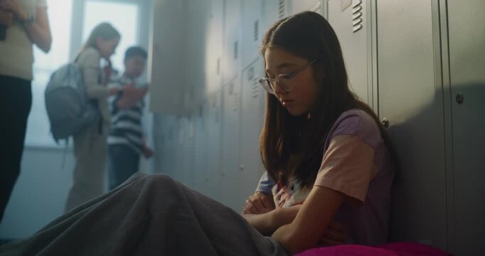 Caring Teacher Notices Distressed Girl Sitting Alone beside Lockers and Gently Sits Down to Offer Comfort and Conversation. Emotional Wellbeing, Student Support, Trusted Teacher Student Relationships.