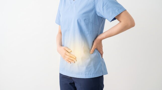 Female nurse or healthcare worker holding lower back in pain, illustrating occupational health hazards, physical strain, and spinal injury risks in medical professions