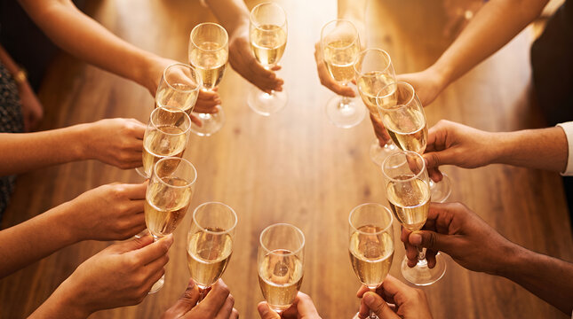 Multiple women holding champagne glasses in celebratory toast gesture