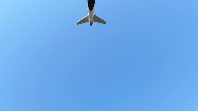 Commercial passenger airplane flying overhead in clear blue sky