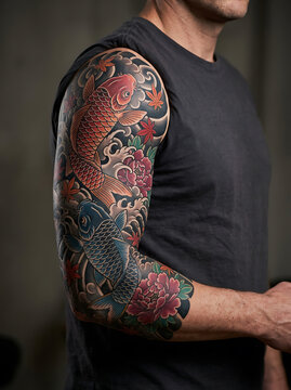 Full sleeve koi fish tattoo on male arm with traditional Japanese floral art design