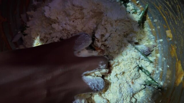 hand mixing flour and vegetables for pakora fry