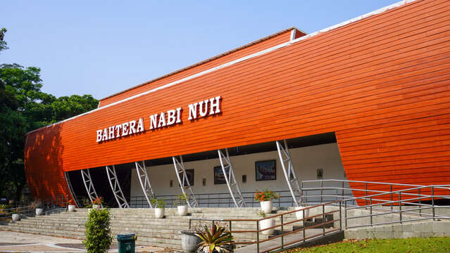 Noah's Ark replica building named Bahtera Nabi Nuh with modern wooden facade surrounded by green trees and tropical plants at Indrokilo Botanical Garden in Boyolali, Central Java, Indonesia.