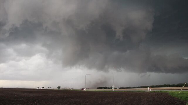 A supercell storm attempts to make a tornado. Dust can be seen spinning near the ground with rotating clouds above. Time lapse.