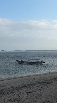 Traditional wooden fishing boat anchored on a calm tropical beach