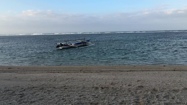 Traditional wooden fishing boat anchored on a calm tropical beach