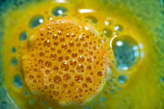 Detailed view of green and yellow bubbling chemical reactive liquid glaze