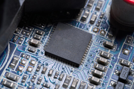 Close-up of microchip on circuit board with electronic components and soldered connections