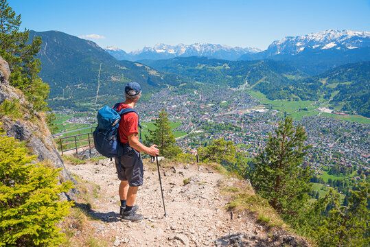 Mountaineer on the adventurous Kramer mountain trail with a view of Garmisch and the Alps.