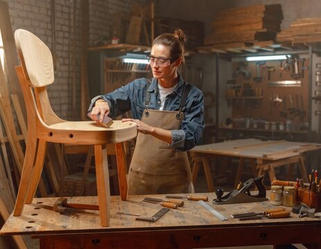 Woman sanding wooden chair