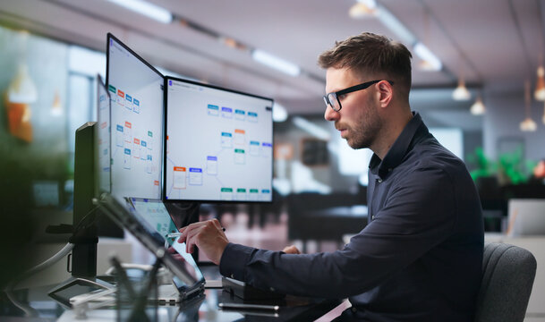 Young Business Analyst Uses Dual Touchscreen Laptops