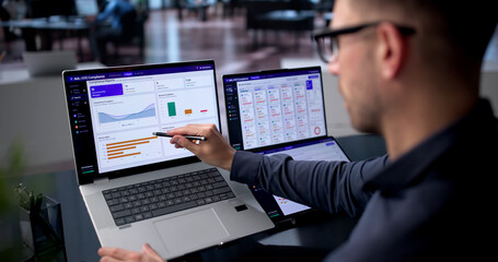 Man Reviews AML Software Dashboard On Laptop