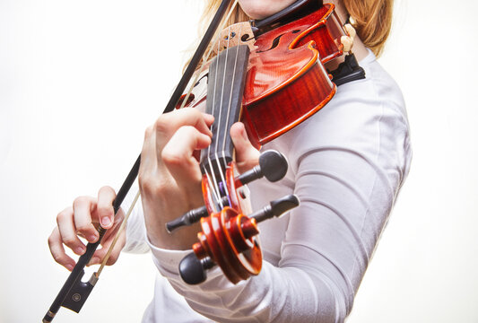 Violin of a classical musical instrument. Hands of a classical violin player on a white background. Details of the violin.