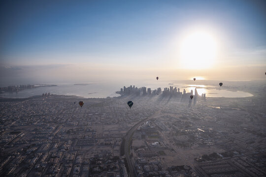 Hot air balloons drift over Doha at sunrise