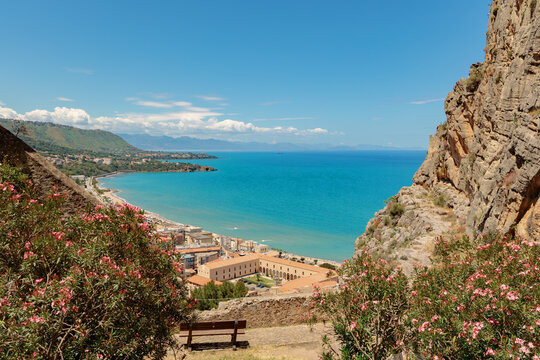 Scenic viewpoint overlooking a coastal town and turquoise sea from rocky cliffs