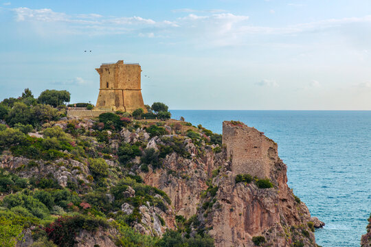 Ancient watchtower perched on a rocky cliff overlooking the blue sea