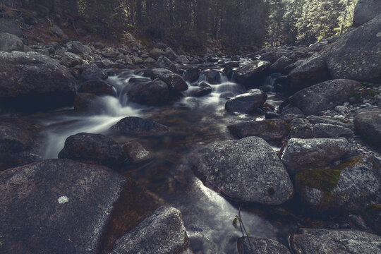 Rocky mountain stream with silky flowing water and boulders