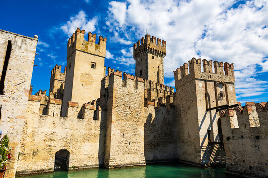 Sunlit facade of the Rocca Scaligera of Sirmione from the port, a medieval fortress and sole access point to the historic center of the town
