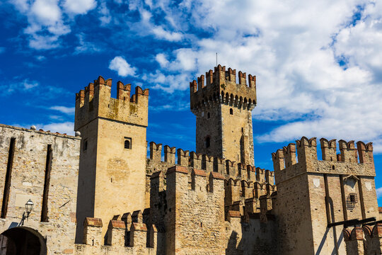 Sunlit facade of the Rocca Scaligera of Sirmione from the port, a medieval fortress and sole access point to the historic center of the town