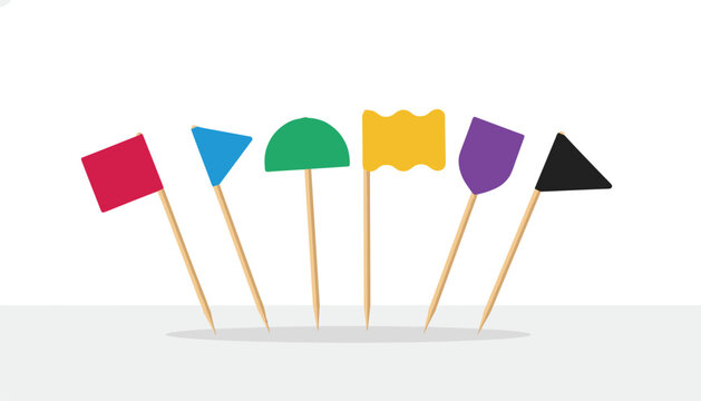 Six colorful mini toothpick flags with geometric shapes stuck in a row on a clean grey and white background.