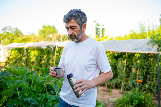 Man taking a break from gardening drinking tea