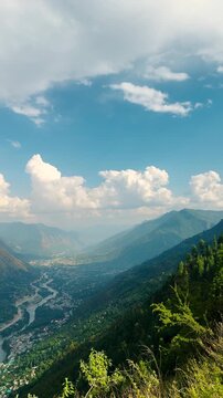 4K Vertical shot of Kullu and Bhuntar city in the Kullu Valley as seen from Peej village on nearby mountain near Kullu in Himachal Pradesh, India. View of the city with buildings on Himalayas.