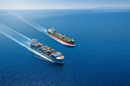 Aerial view of a cargo container ship and a crude oil tanker crossing the ocean as a concept for industrial transport