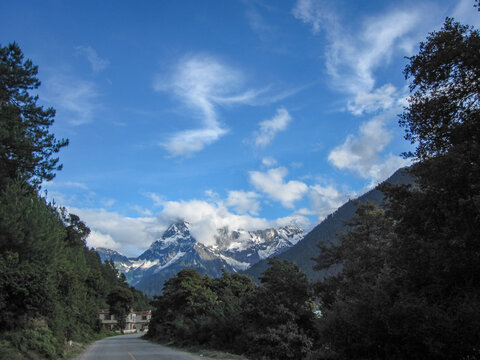 Scenic mountain road with clear blue sky and snow-capped peaks