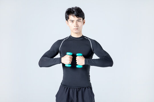 Athletic man doing dumbbell chest exercise in studio