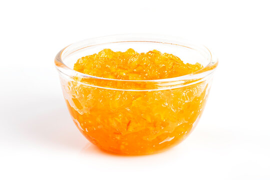 Orange jam in glass bowl isolated on white background. for breakfast themes, bakery ingredients, gourmet food spreads, and healthy natural snacks.