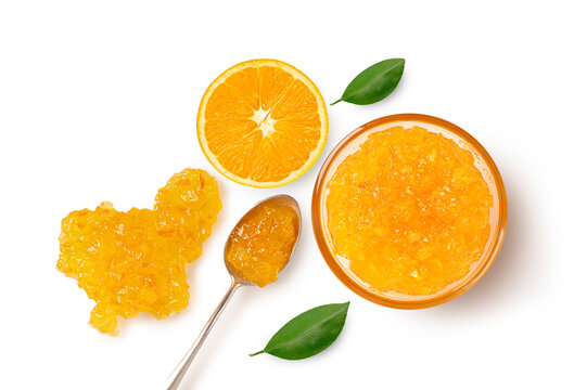 Glass bowl of orange jam, with half orange and green leaf and Isolated on white background. Top view