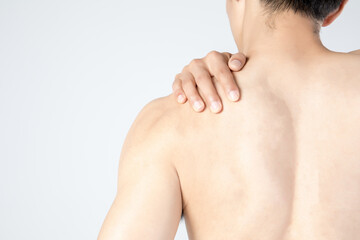 Naklejka premium Shirtless man holding painful shoulder from behind