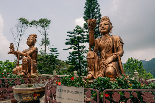 The Six Devas statues presenting offerings, surrounding the pedestal at the base of the famous Tian Tan Big Buddha near Po Lin Monastery on Lantau Island, Hong Kong, China - August 22, 2026.