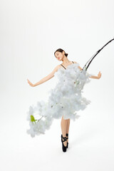 Graceful ballerina with white blossoms in minimalist studio © LuuNhan