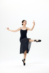 Elegant ballerina in black dress performing ballet pose on pointe © LuuNhan