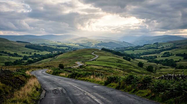 Winding asphalt road through green rolling hills under a cloudy sky