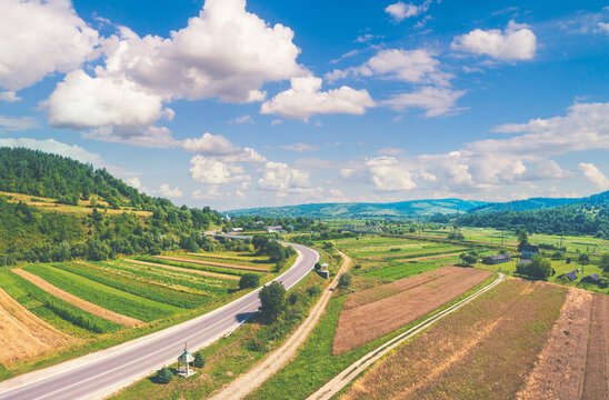 Aerial view of the countryside, highway, and cultivated fields on the hills
