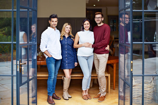 Smile, couple of friends or group in home for portrait, gathering or support for expecting parents. Embrace, pregnant woman and partner in house for get together, maternity or godparent visit