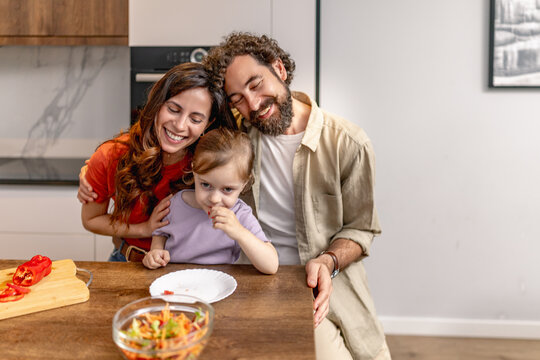 Happy family of three sharing a relaxed meal and bonding in a modern kitchen