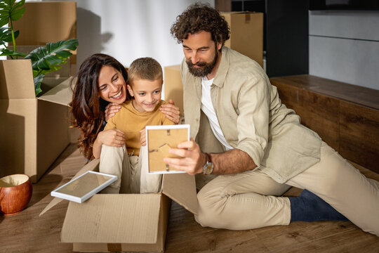 Happy family unpacking boxes and making memories in new home after moving day