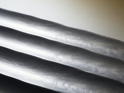 Close-up of wavy Damascus steel blade patterns highlighting intricate metal texture and craftsmanship
