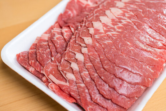 Raw meat slices on white tray